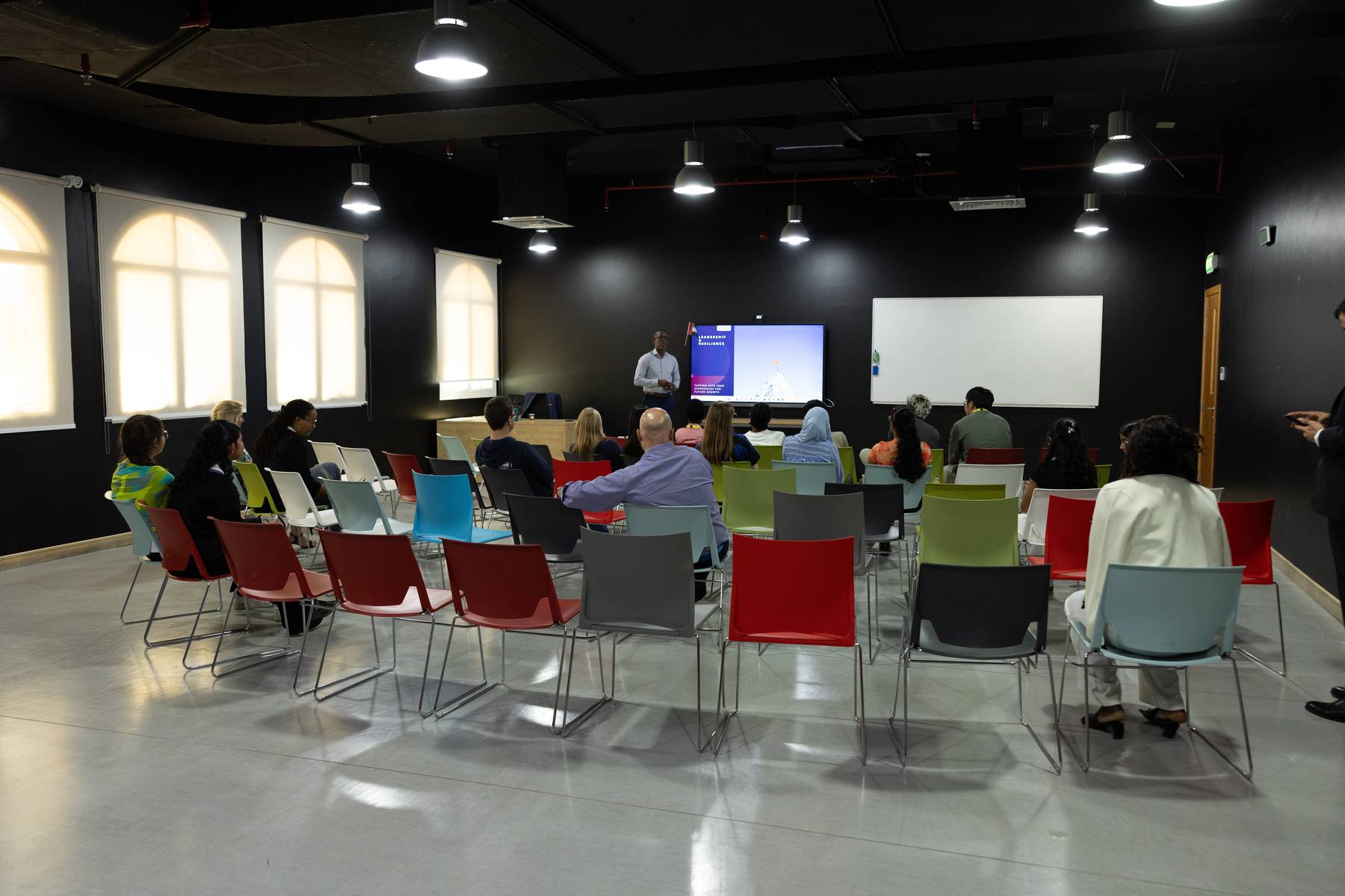 A presenter leading a leadership workshop for young people and community members.