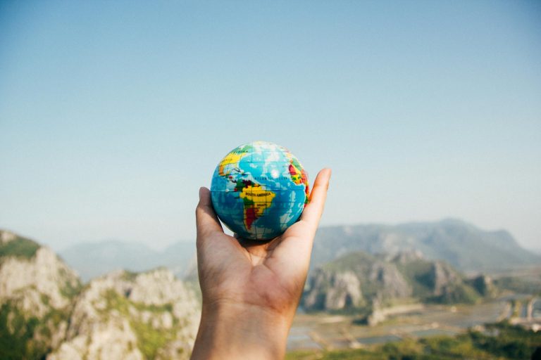 A hand holding a globe to represent international study destinations.