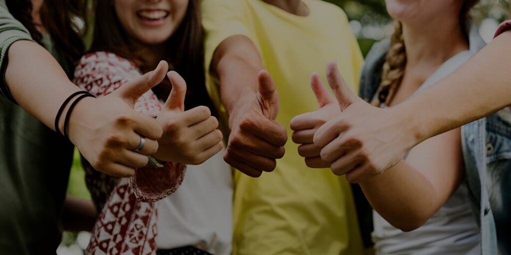 Young people sharing positive thumbs-up gestures.