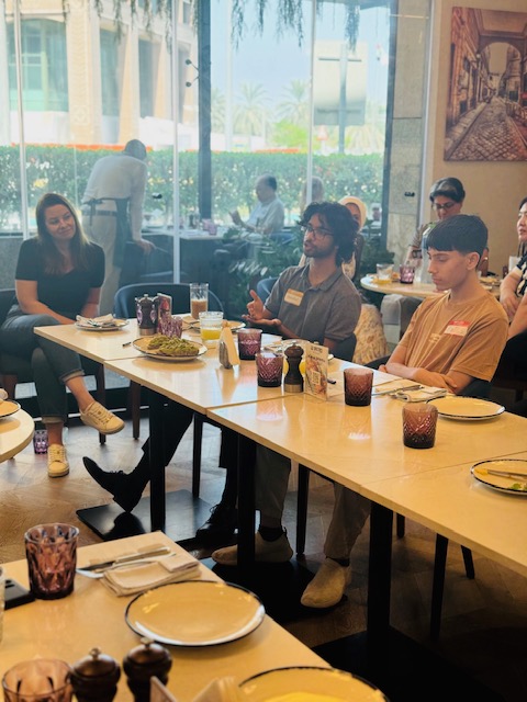 A mentor responds while students follow the discussion around the table.