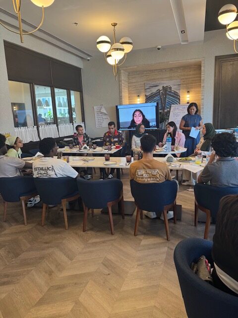A full-room view of students and mentors seated for a forum conversation.