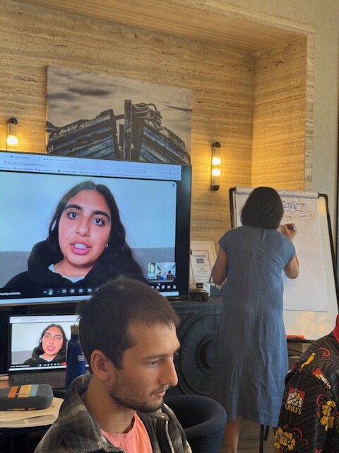A remote speaker appears on screen while the group works through ideas.