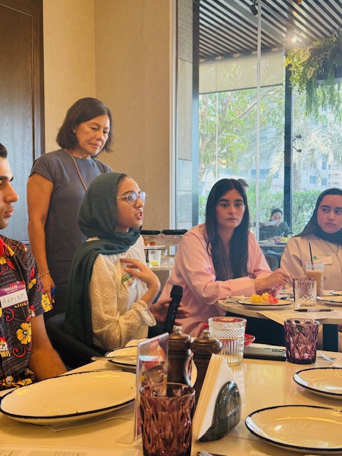 A young participant speaks during a round-table conversation with peers and mentors.