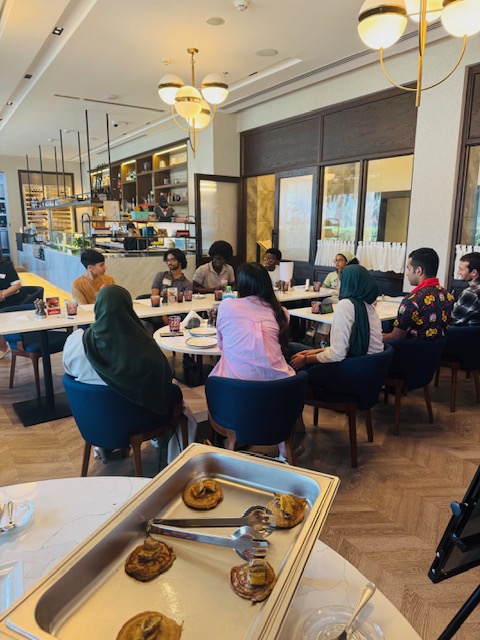 Young people take part in a focused discussion around a shared table.